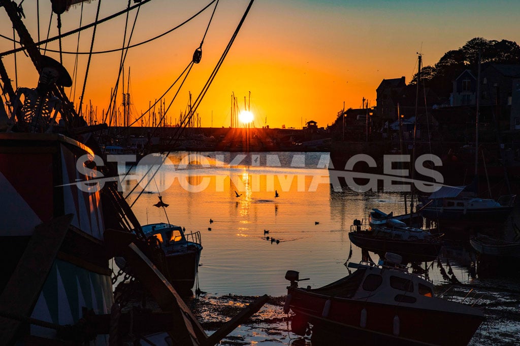 The Golden Hind and the dawn sunrise with incoming tide at Brixham Harbour, Devon.