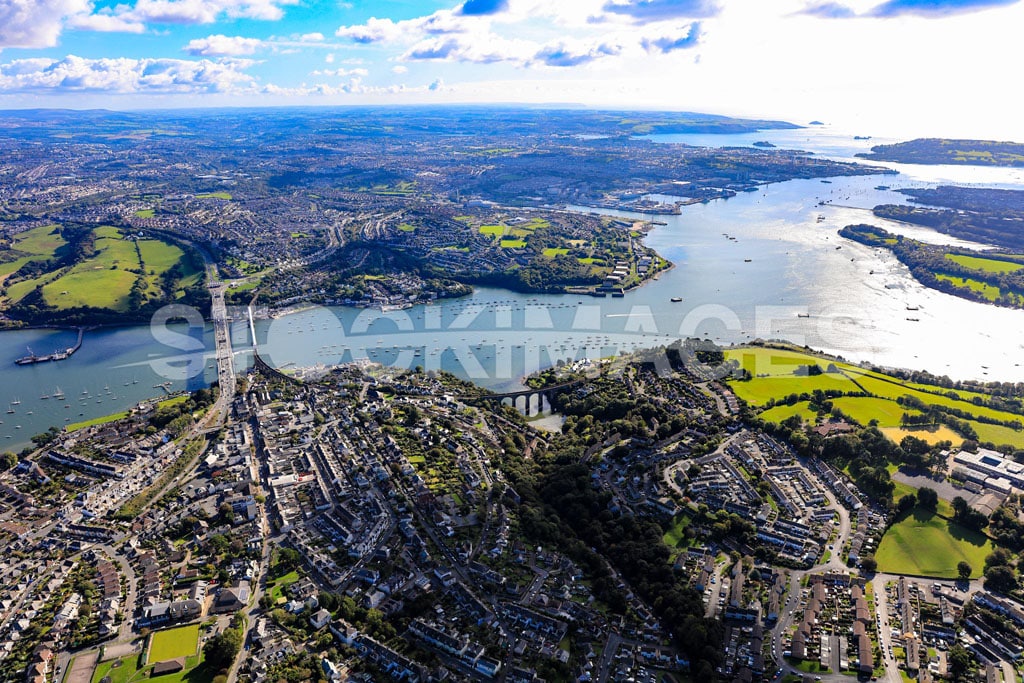 Aerial image of the Tamar Bridge in Plymouth, Devon, agaist the sun shining on the water with a long distance view out to sea.