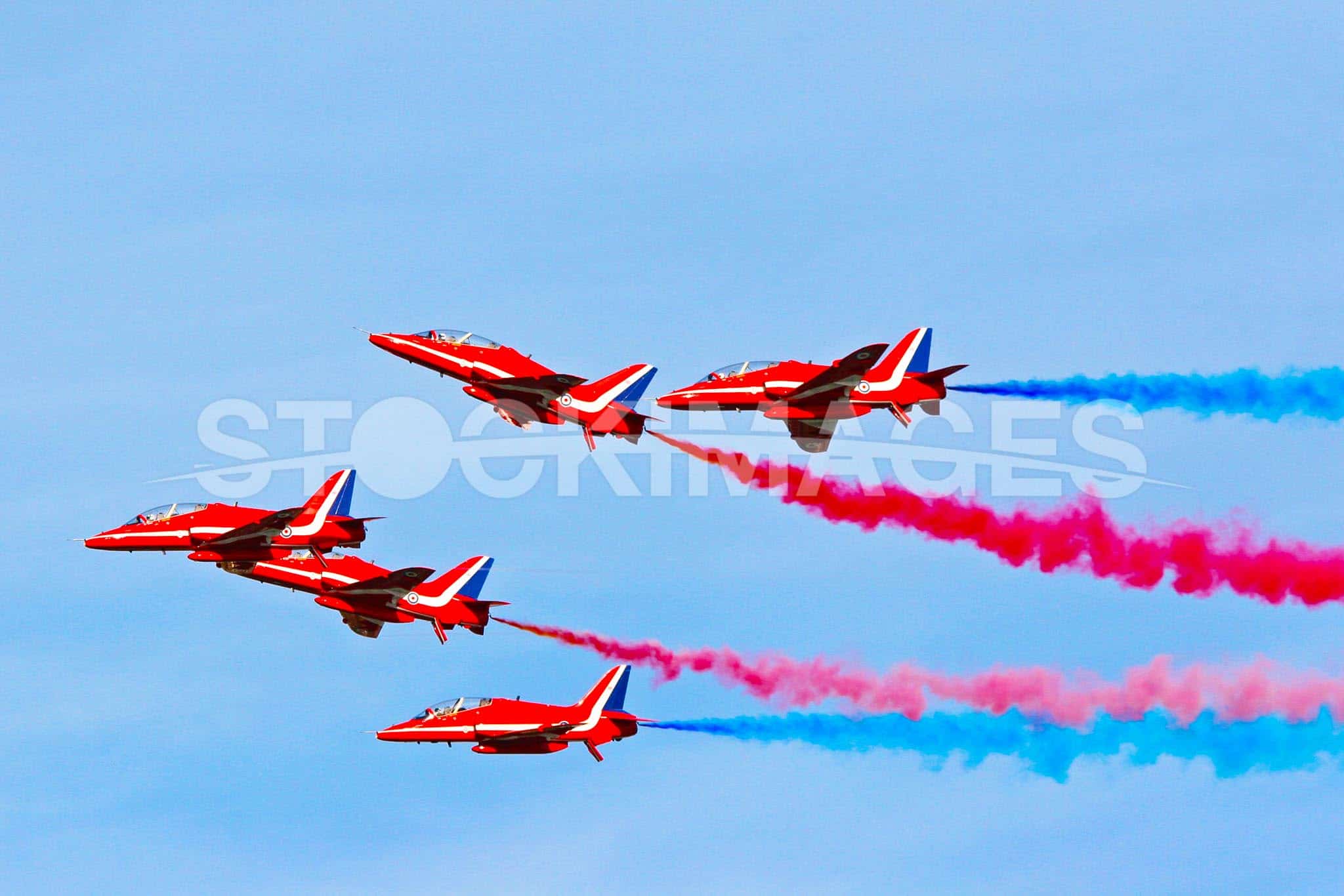 The RAF Red Arrows displaying at Dartmouth, their vibrant colours piercing the sky.
