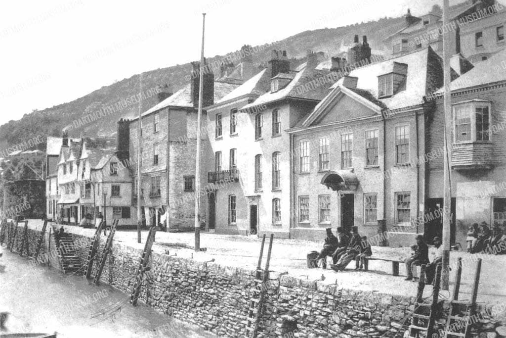 Historical photograph of Dartmouth's iconic Bayards Cove looking towards the Fort, with seats near ladders where coal lumpers sat ready to dash for boats that wanted coaling.