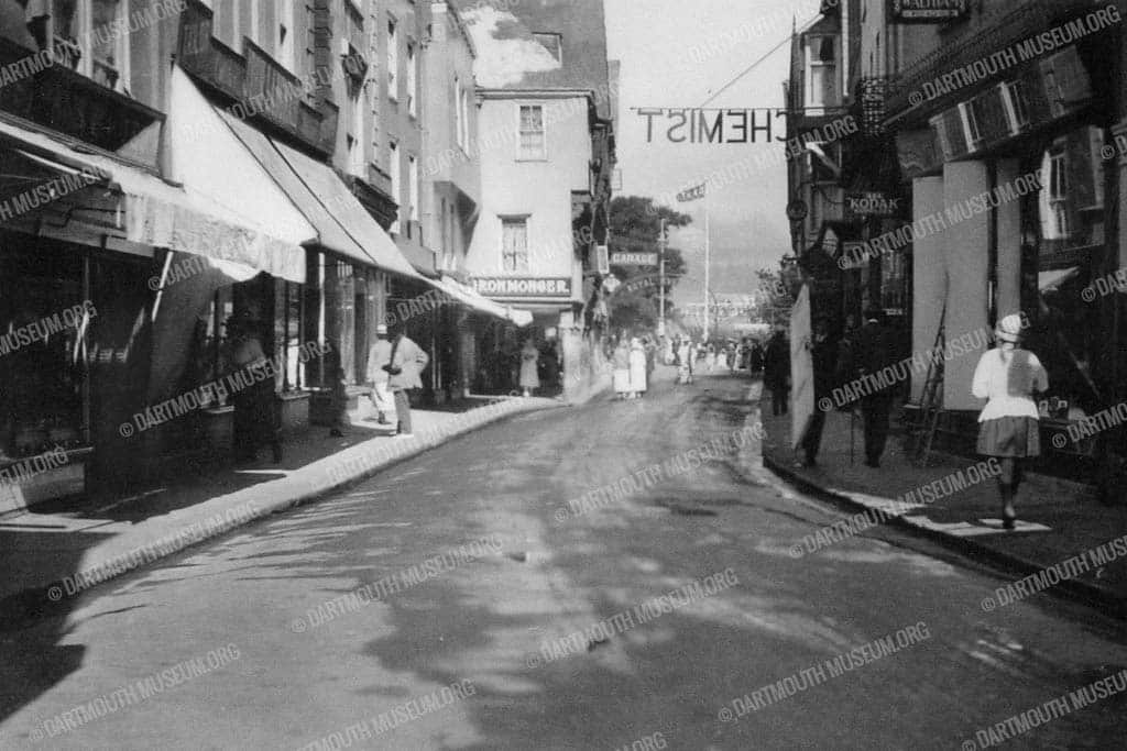 Historical photograph of Duke Street in Dartmouth looking towards the Butterwalk in 1925. All shops left were demolished by a bomb in February 1943.
