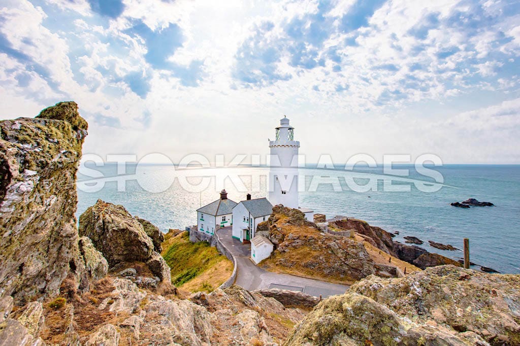 Start Point Lighthouse on the peninsular looking out to sea, surrounded by rocky coastline.