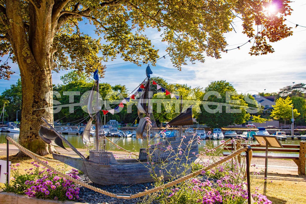 Image of the Mayflower memorial in Kingsbridge surrounded by flowers from Kingsbridge in Bloom in gentle sunlight.